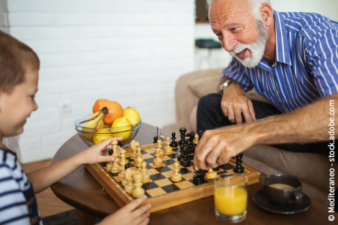 Senior spielt mit Enkel Schach