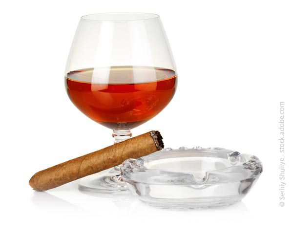 Glas Alkohol und eine Zigarre im Aschenbecher
